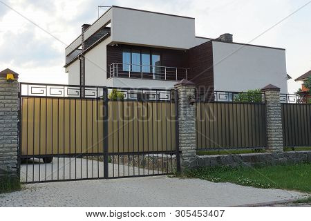 Gray Metal Gate And Fence In Front Of A Private House With A Balcony