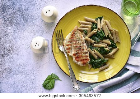 Whole Wheat Penne Pasta With Spinach And Grilled Chicken Breast.top View With Copy Space.