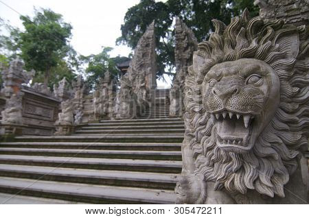 Picture Of A Lion Stone Statue With A Typical Balinese Gate Entrance In The Backround. This Is Locat