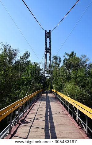 Mountain Bridge Over The River With Yellow Railings In The Summer On Mount Kizilovka In The Foothill