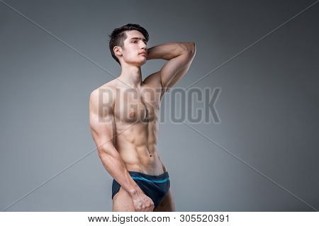 Young Male Athlete Bodybuilder Posing. Handsome Athletic Male Power Guy. Fitness Muscular Person. Yo