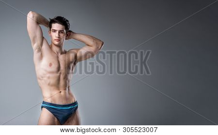Young Male Athlete Bodybuilder Posing. Handsome Athletic Male Power Guy. Fitness Muscular Person. Yo