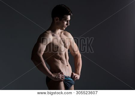 Young Male Athlete Bodybuilder Posing. Handsome Athletic Male Power Guy. Fitness Muscular Person. Yo