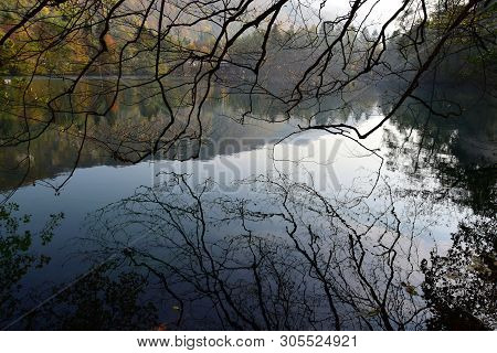 View Of The Evening Karst Blue Lake With Tree Branches In The Fall In Cherek Gorge In The Mountains 