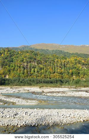 View Of A Mountain River With Stones And Mountains With Green Trees In The Cherek Gorge In The Mount