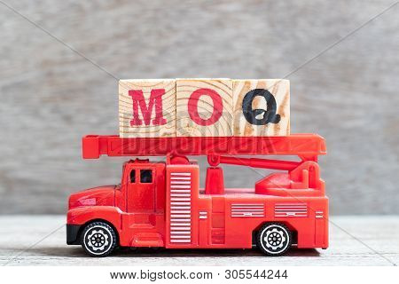 Red Fire Truck Hold Letter Block In Word Moq (abbreviation Of Minimum Order Quantity) On Wood Backgr