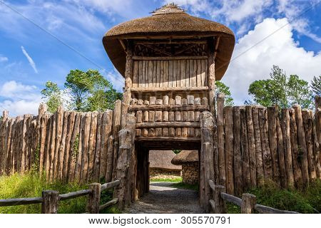 Entrance Trough Gate In Palisade And Guard Tower To Old Thatch And Stone Celtic Cottage, Concept Of 