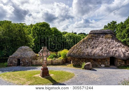Ancient Thatch And Stone Cottage With Celtic Cross In Centre, Concept Of Early Age Human Settlement,