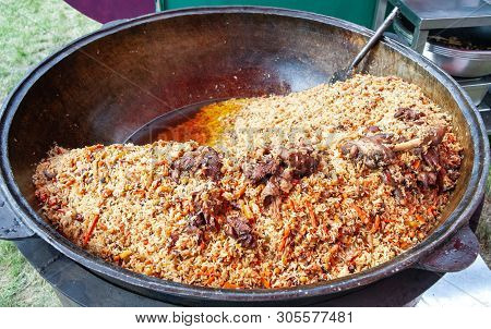Real Pilaf In A Huge Cauldron. Cooking National Dishes. Traditional Pilaf Cooking.
