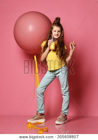 Young Teen Girl In Jeans And Yellow T-shirt Stepped On Big Pink Balloon Yellow Tape, Drinks Yellow J