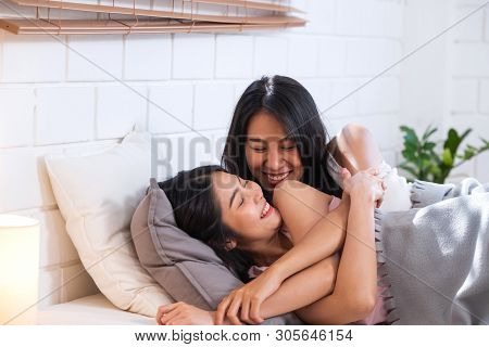 Happy Lesbian Couple Wake Up On Bed In Bedroom In Morning And Hug Each Other At Home.lgbtq Lifestyle