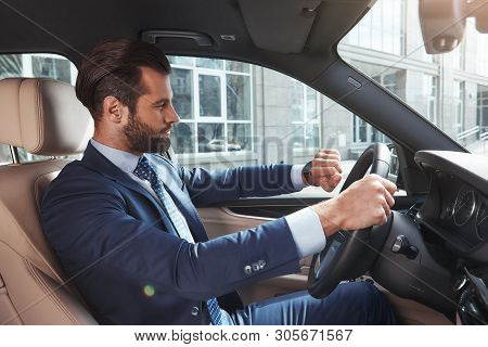 I Should Be In Time. Side View Of Confident And Successful Bearded Businessman Is Looking At Watch O