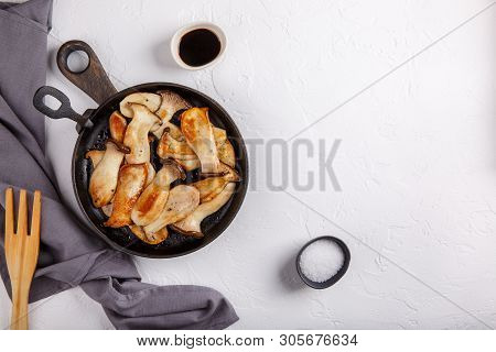Fried Eryngii Mushrooms In Cast-iron Pan On White Table. Grilled Slices Of King Oyster Mushrooms. To