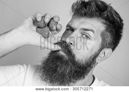 Fresh Juice Concept. Hipster Bearded Holds Strawberries Fist As Juice Bottle. Man Strict Face Enjoy 