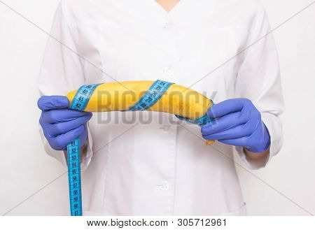 Doctor Holds Banana In Hand With Measuring Tape. Concept Of Increasing Male Penis And Operation, Inc