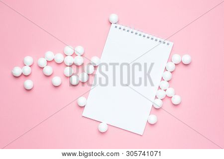 Business Notebook And White Plastic Balls On Pink Background. Abstract Concent.