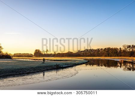 Dutch River Mark Early In The Morning On A Sunny And Windless Day In The Winter Season. An Unknown W