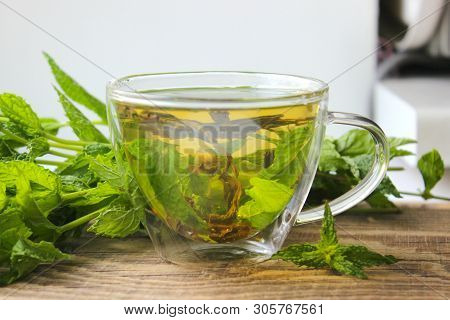 Natural Mint Tea And Fresh Mint Leaves On Wooden Rustic Background.