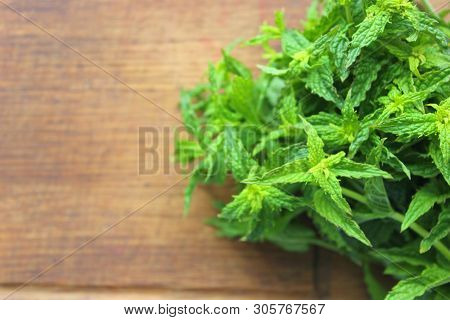 A Bunch Of Fresh Green Mint On A Wooden Rustic Table. Copy Space.
