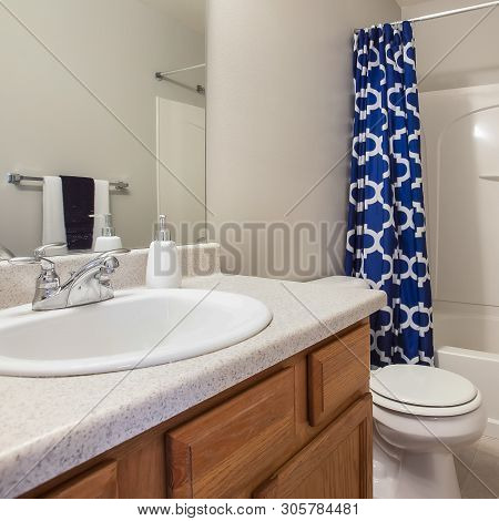 Square Small Bathroom Interior With A Vanity Unit And Toliet Against The White Wall