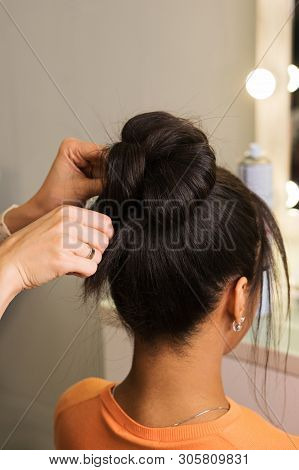 Hair Stylist Hands Fix High Bunch Of Hair. Learning To Create An Evening Hairstyle. Hairdressing Wor