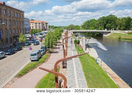 City Jelgava, Latvian Republic. River Lielupe, Peoples And Urban City View. Houses And Walking Paths