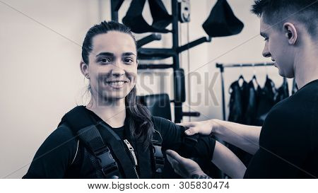 Smiling Woman Preparing For Ems Training And Wearing Vest