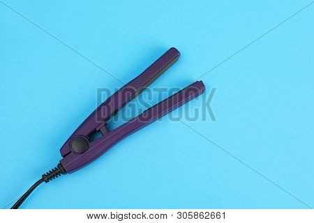 Modern Hair Iron For Straightening On Color Background, Top View