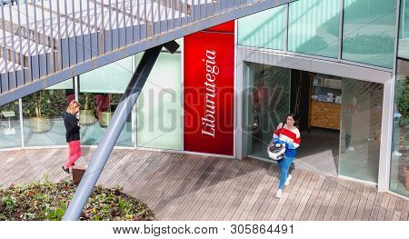 Irun, Spain - April 27, 2018: Woman Coming Out Of The Carlos Blanco Aguinaga Library Near The Town H