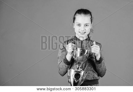 She Is The Best. Small Girl Holding Silver Cup. Little Child With Cup Shaped Sports Trophy. Cute Ath
