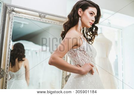 Beautifu bride choosing wedding dress in a wedding salon