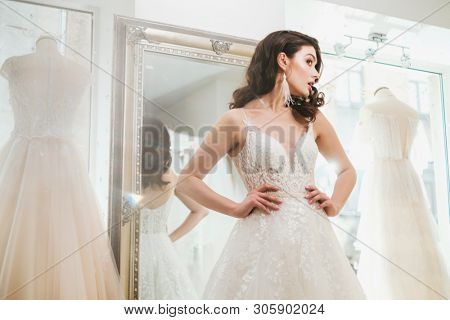 Beautifu bride choosing wedding dress in a wedding salon