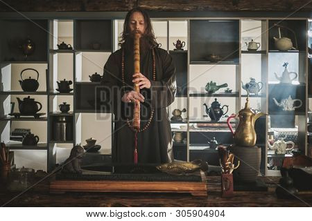 Tea master playing flute before tea ceremony