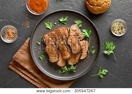 Grilled Sliced Beef Liver On Plate Over Black Stone Background. Cooked Liver(offal) From Beef Meat. 