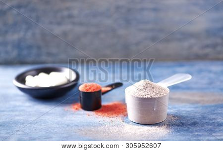 Scoop Of Whey Protein, Creatine Powder And Taurine Capsules. Sport Nutrition. Rustic Wooden Backgrou