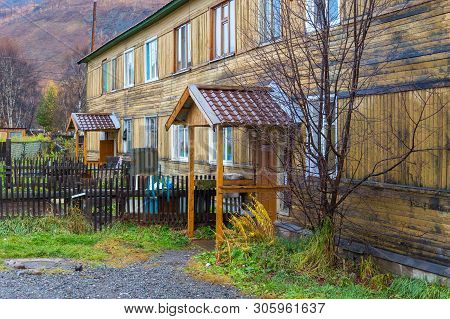 Esso, Kamchatka Peninsula, Russia- 02 October 2014: Wooden Yellow Building. Housing Estate In A Smal