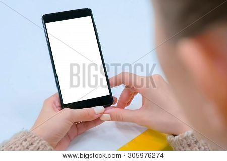 Mockup Image: Woman Looking At Black Smartphone With White Blank Screen. Close Up View Of Woman Hand