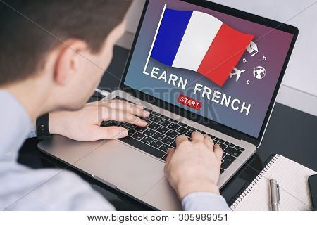 Man Working On Laptop With Learn French On A Screen. Education Learning French Language School Conce