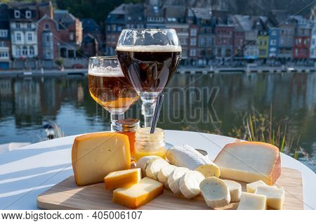 Glass Of Belgian Abbey Beer And Tasting Of Cheeses Made With Trappist Beer And Fine Herbs With View