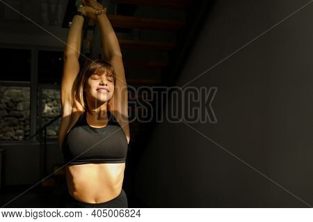 Relaxed Yoga Girl With Arms Raised Up. Slender Woman Doing Morning Workout