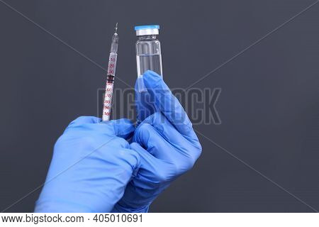 Doctor, Nurse Or Scientist Hand In Blue Nitrile Gloves Holding Flu, Measles, Coronavirus Vaccine Sho