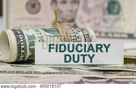 Finance And Economics Concept. On The Table Are Bills, A Bundle Of Dollars And A Sign On Which It Is