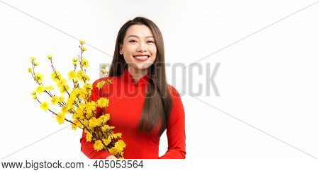 Young Asian Beauty Woman Wearing Ao Dai And Holding Ochna Integerrima Branch With Flower In Lunar Ne
