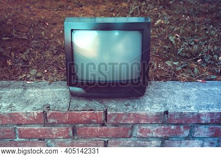 Toned Photo Of Old Analog Television Set On The Street Outdoor