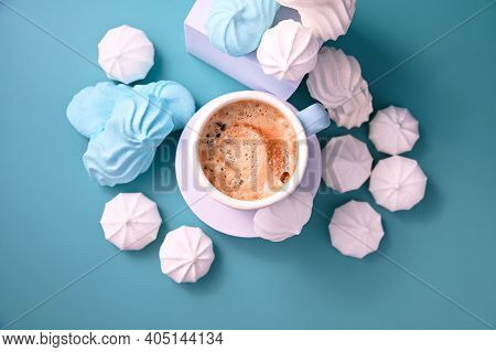Meringue. Espresso With Froth And Meringues Of Different Colors On A Blue Background. A Creative Sho