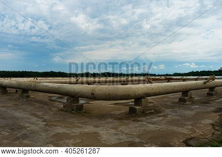 Pipes Of The Cooling System Of A Thermal Power Plant On Concrete Supports. Empty Spray Pond Cooling 