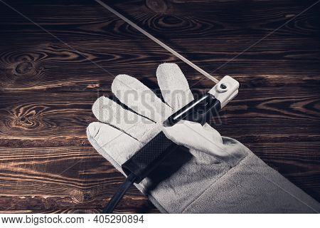 The Holder Of The Welding Electrode With An Electrode, Lie In A Welding Glove On A Wooden Background