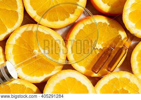 Glass Petri Dish With Transparent Pure Serum For Skin Care With Ampulas Over Natural Orange Slices, 