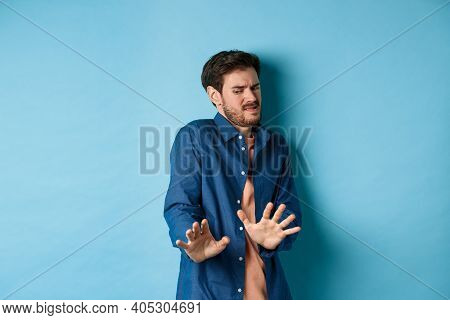 Image Of Man Cringe And Look At Something Disgusting, Step Back From Awful Thing And Block It With H