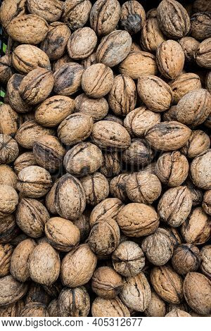 Top View Of Unshelled Browned Walnuts On The Counter In Greek Market. Natural Food Background Of Nut